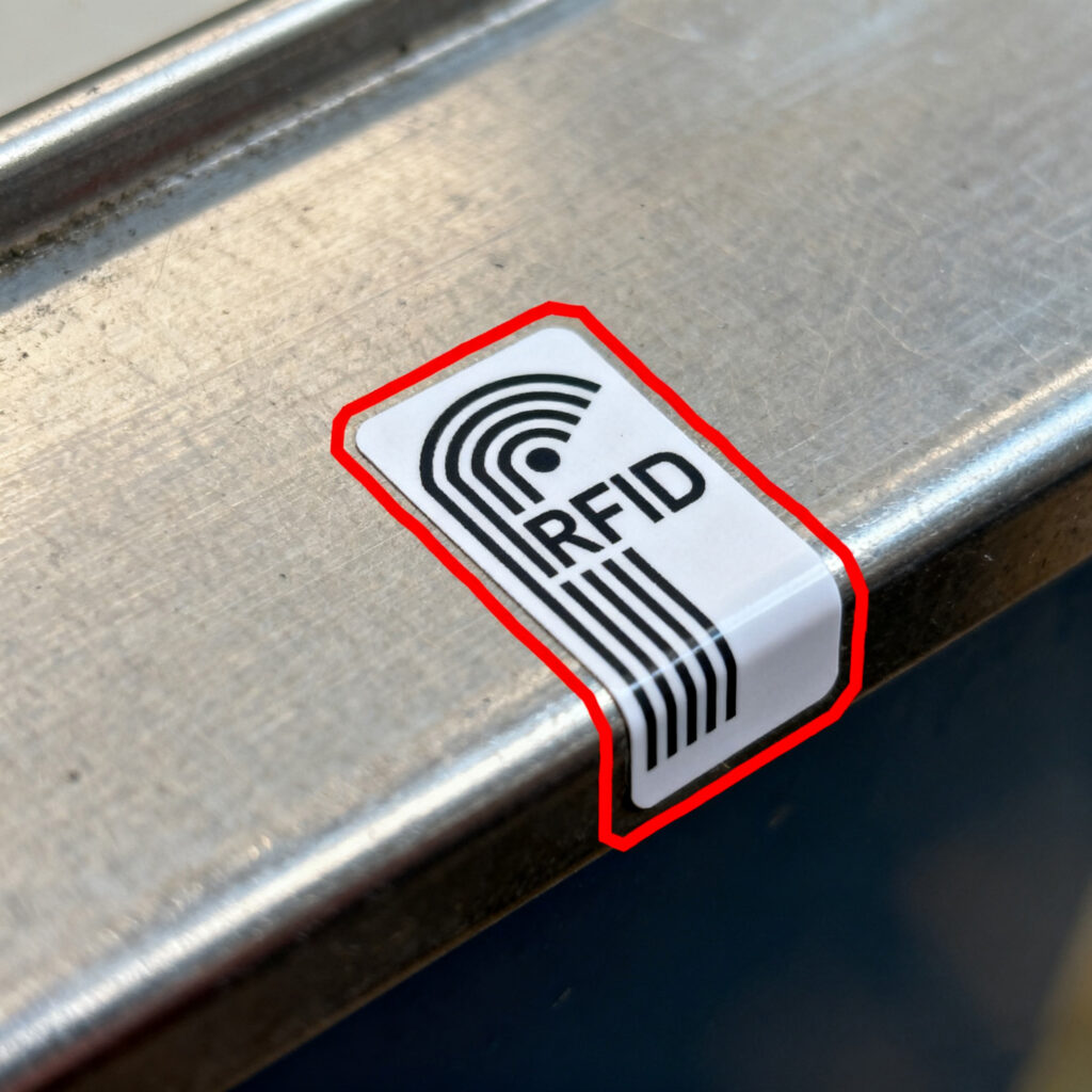 Misplaced RFID tag on a metal surface that could cause read errors.