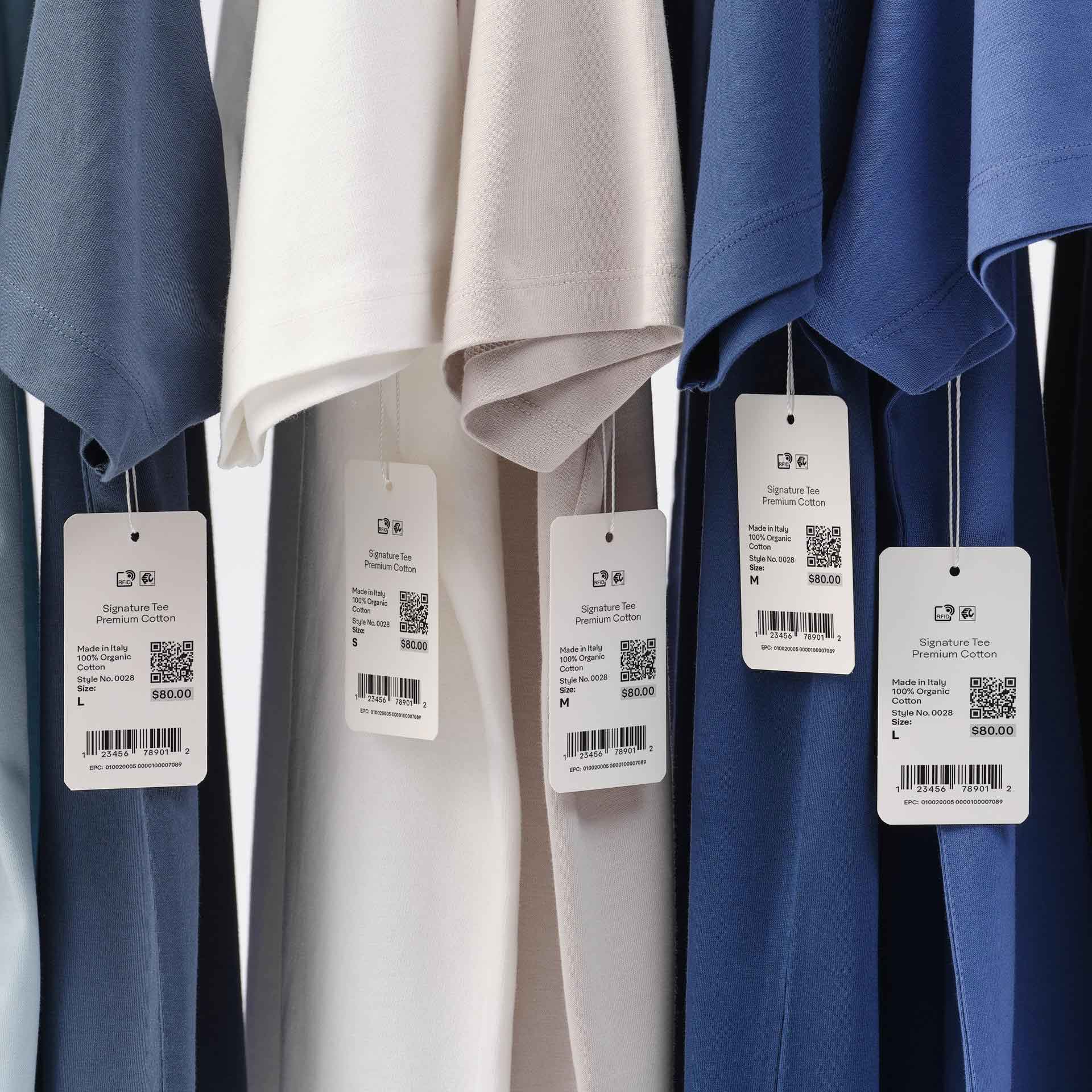 RFID-enabled paper hangtags attached to garments on a clothing rack in a modern fashion store.