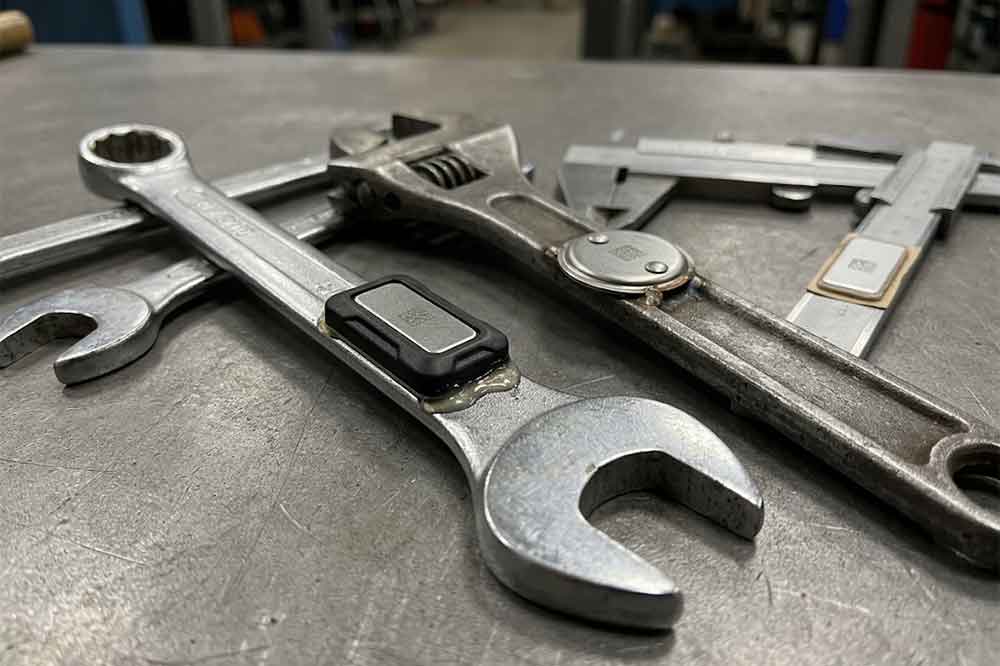 Industrial RFID tags attached to metal hand tools for equipment identification.